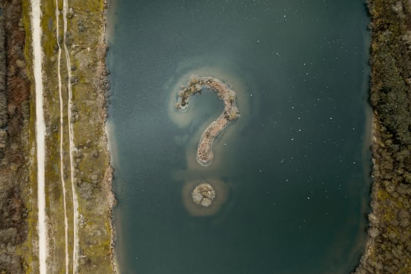 A lake with an island shaped as a question mark in the middle.